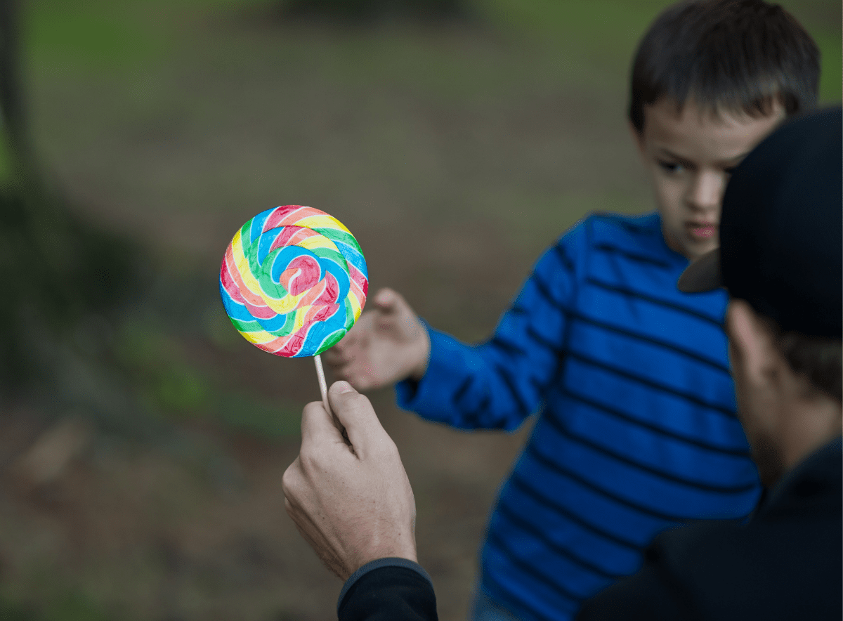 Stranger offers rainbow lollipop to hesitate young boy