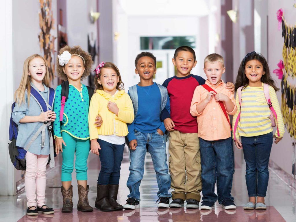 Smiling children line up in school hallway